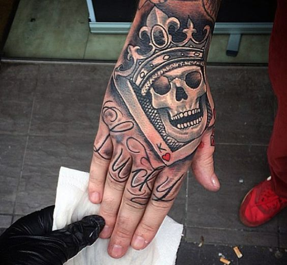 Crown and skull tattoo on hand