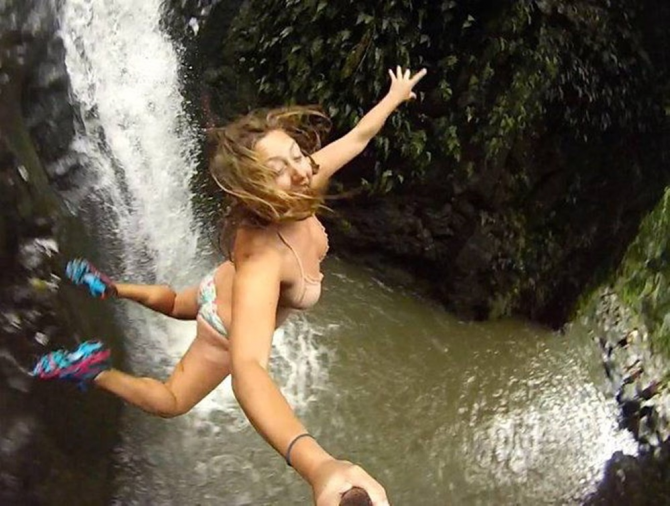 Selfie som hoppar i ett vattenfall